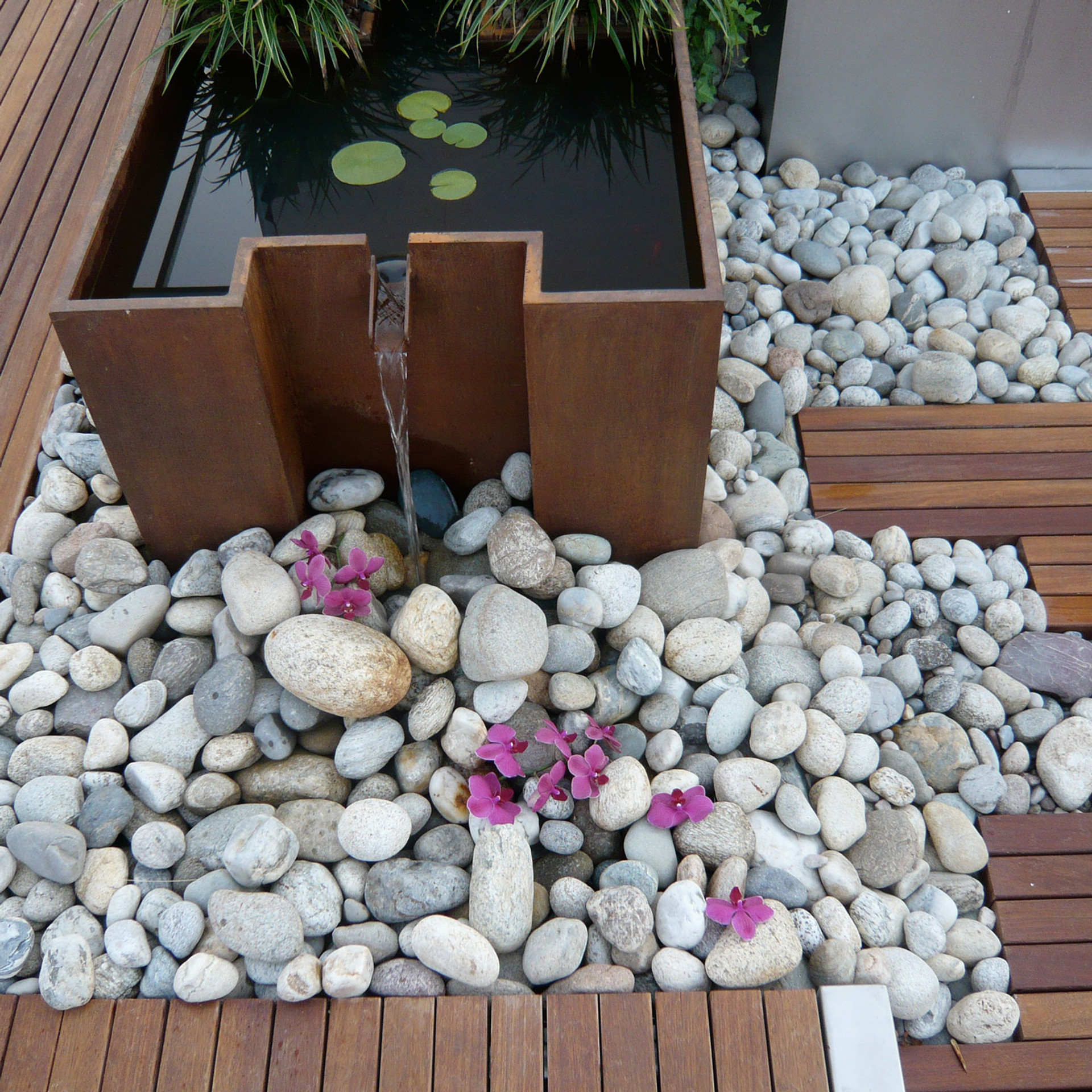 Contemporary corten steel water feature with lily pad pond