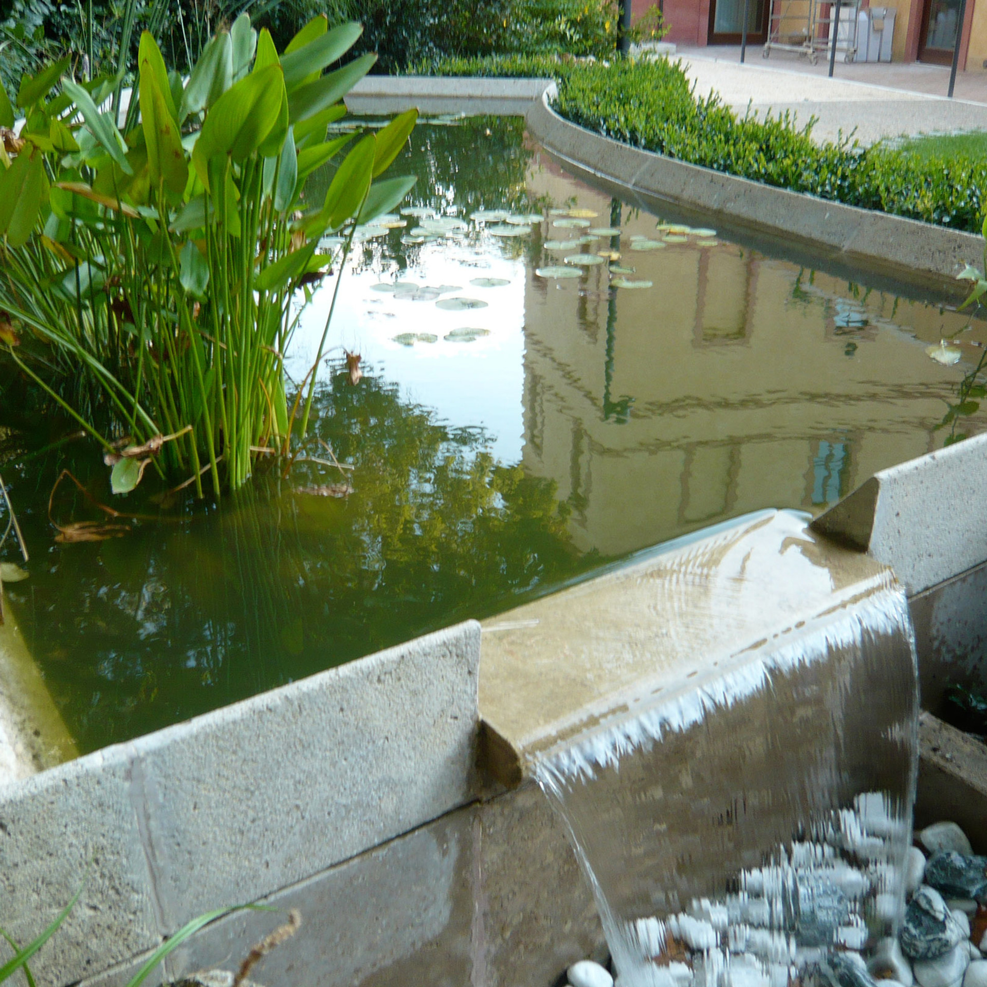 Stone-edged garden pond with water cascade